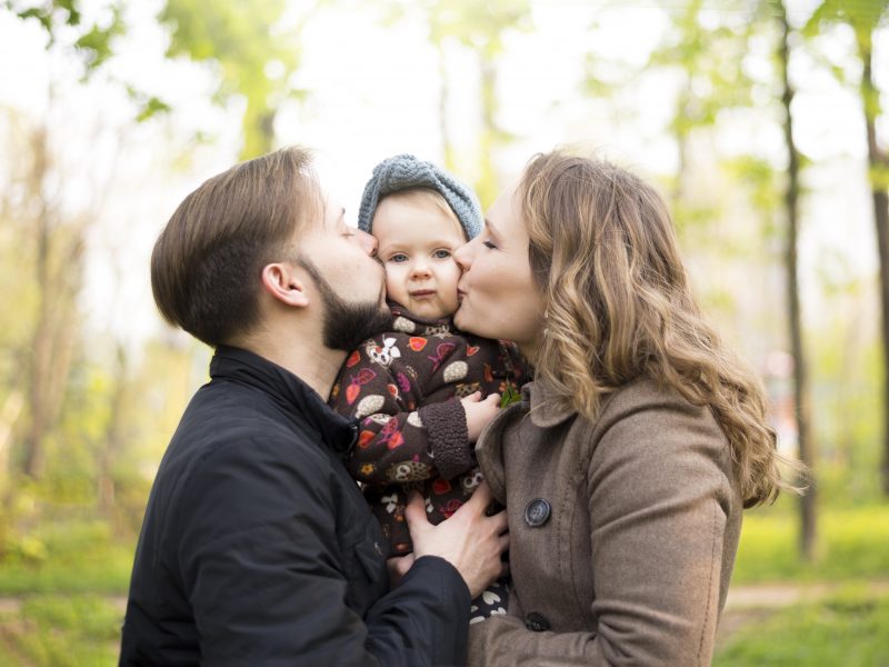 Happy Parents With Child In Nature